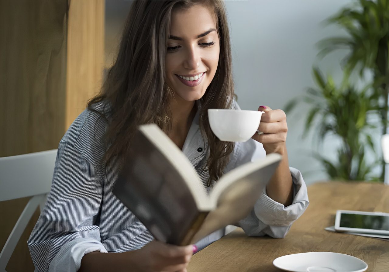 New Project (14) (1) A woman is drinking coffee and reading a book.